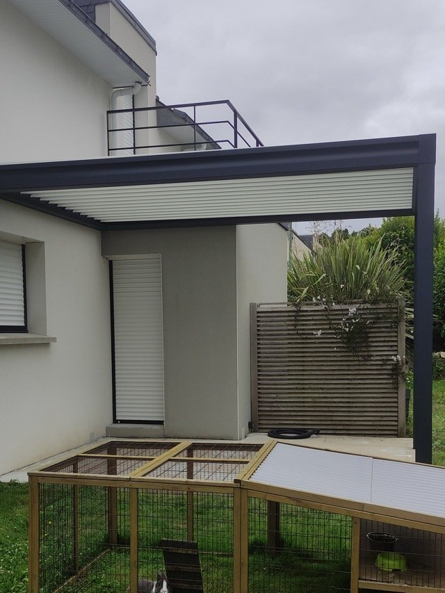 Pergola bioclimatique anthracite posée sur une dalle béton à Guidel