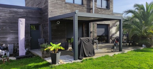 Pergola bioclimatique adossée à une maison en bardage bois à Plougoumelen